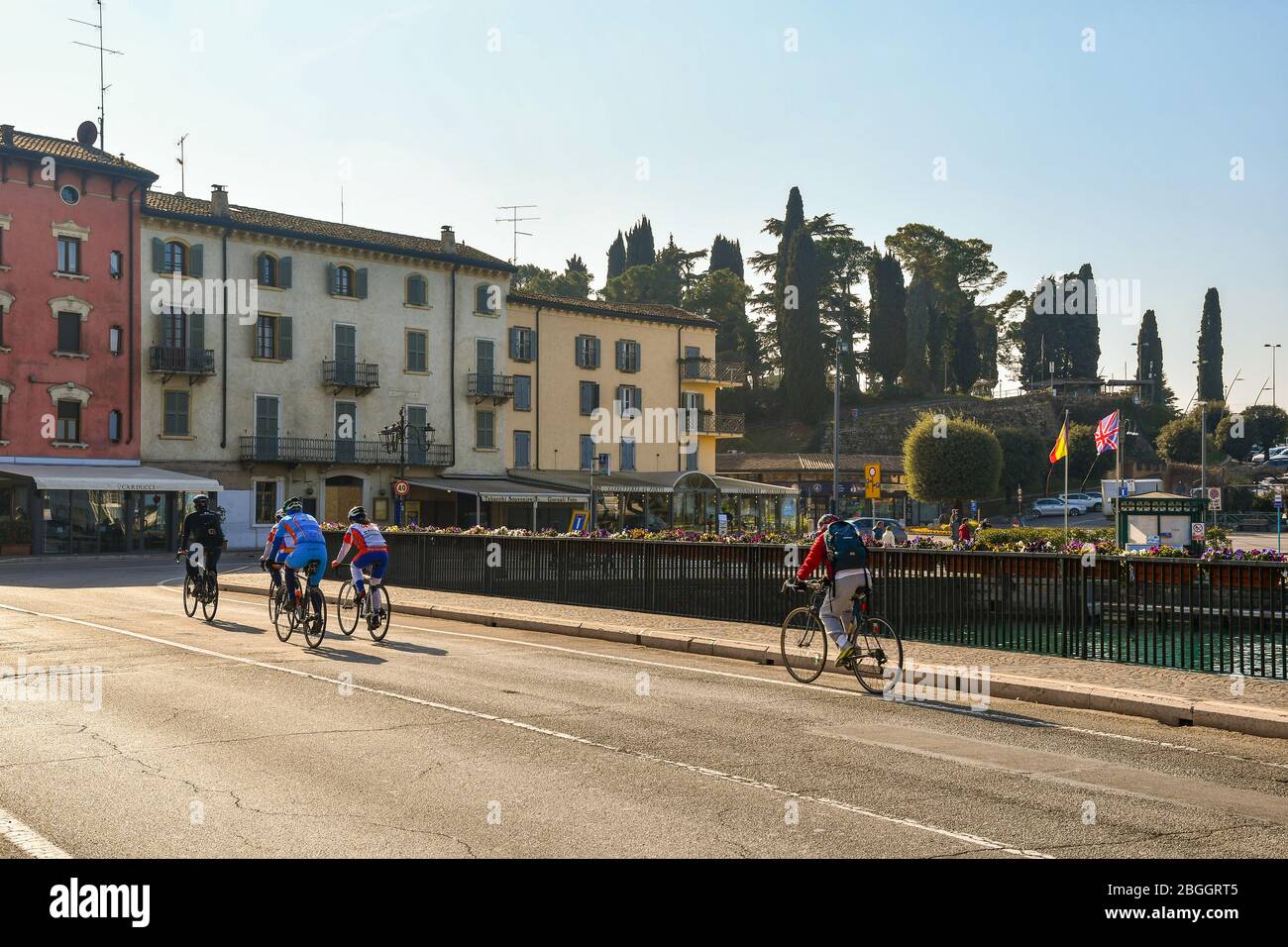 A group of cyclists passing on the bridge over the Middle Canal (Canale di Mezzo) in the old town of Peschiera del Garda, Verona, Veneto, Italy Stock Photo