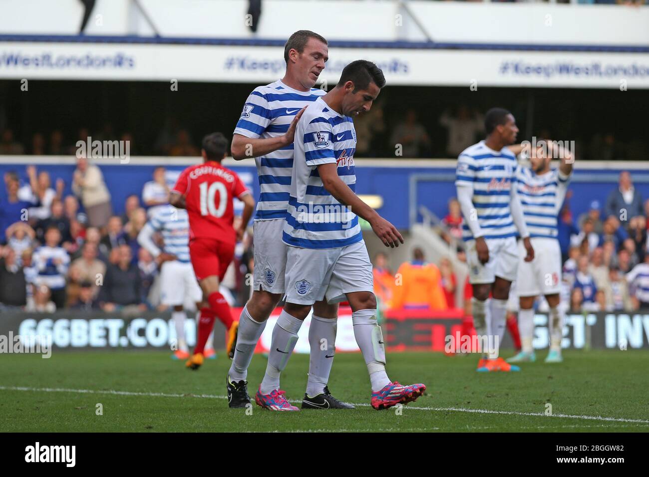 LONDON, ENGLAND.  Queens Park Rangers Defender Richard Dunne apologises to Queens Park Rangers Midfielder Mauricio Isla for scoring a own goal in the second half during the Barclays Premier League Match between Queens Park Rangers & Liverpool at Loftus Road, London on Sunday October 19th 2014 (Credit: MI News) Stock Photo