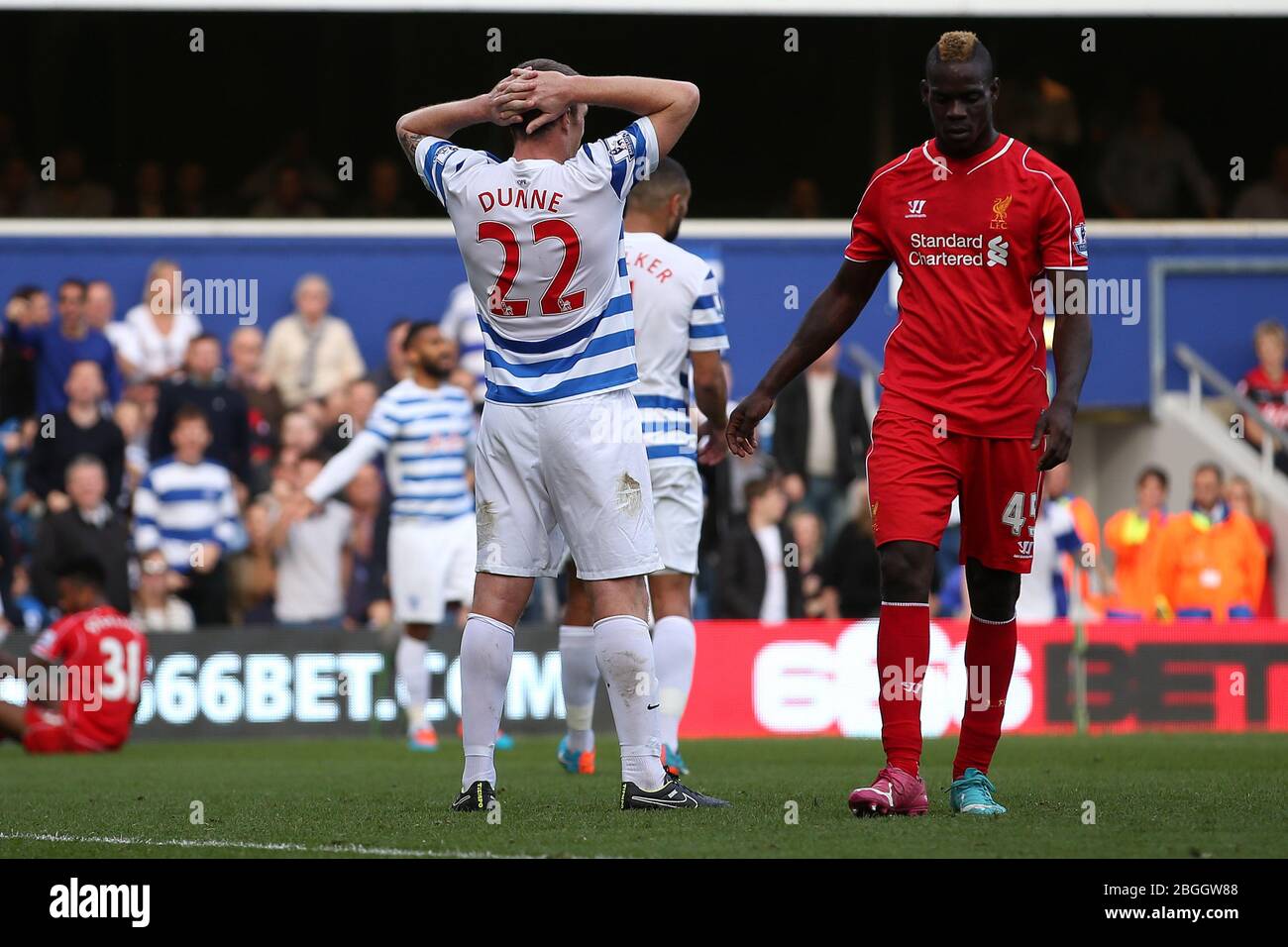 LONDON, ENGLAND. Liverpool's Mario Balotelli looks on as Queens Park Rangers Defender Richard Dunne holds his head as he scores a own goal in the second half during the Barclays Premier League Match between Queens Park Rangers & Liverpool at Loftus Road, London on Sunday October 19th 2014 (Credit: MI News) Stock Photo