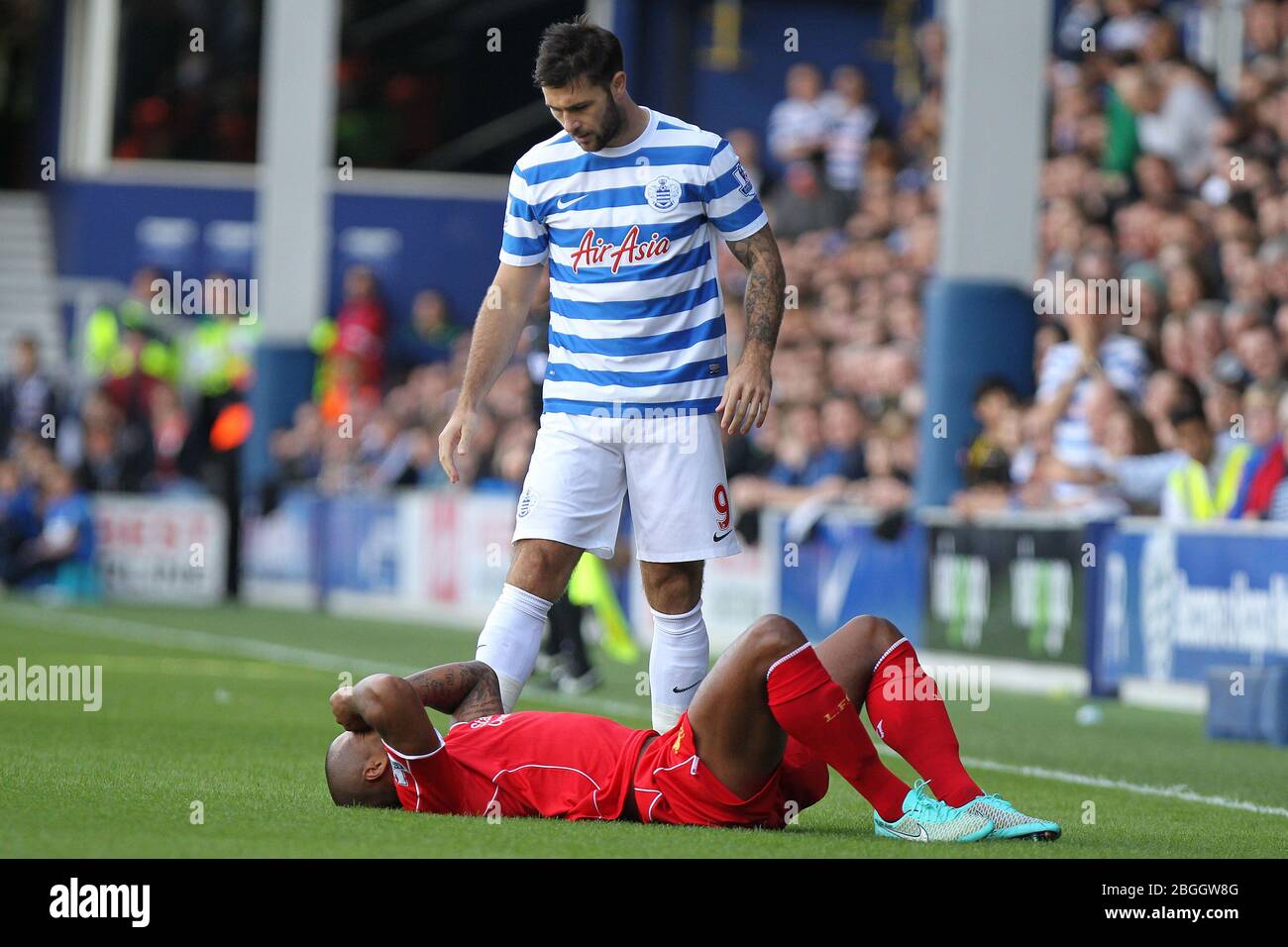 LONDON, ENGLAND.  Queens Park Rangers Forward Charlie Austin stands over Liverpool Defender Glen Johnson as he goes down injured in the first half during the Barclays Premier League Match between Queens Park Rangers & Liverpool at Loftus Road, London on Sunday October 19th 2014  (Credit: MI News) Stock Photo