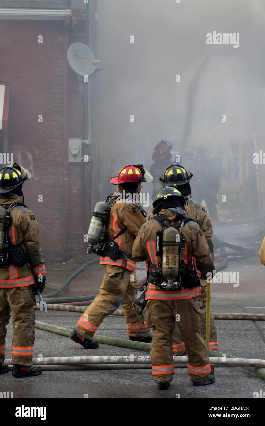 Fire fighters battling blaze with heavy smoke. 911 emergency house fire