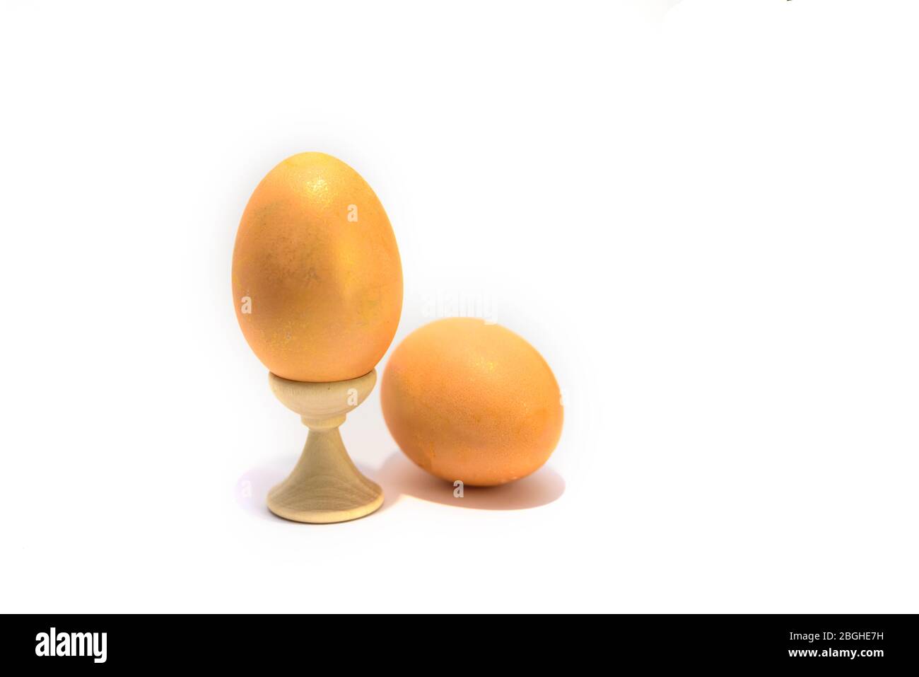 Two colored easter chicken eggs isolated on the white background. One is in holder. Stock Photo