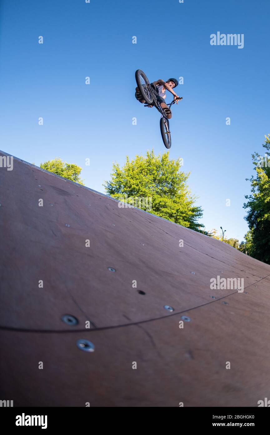 Biker jump high from jump box ramp performing look back trick Stock ...