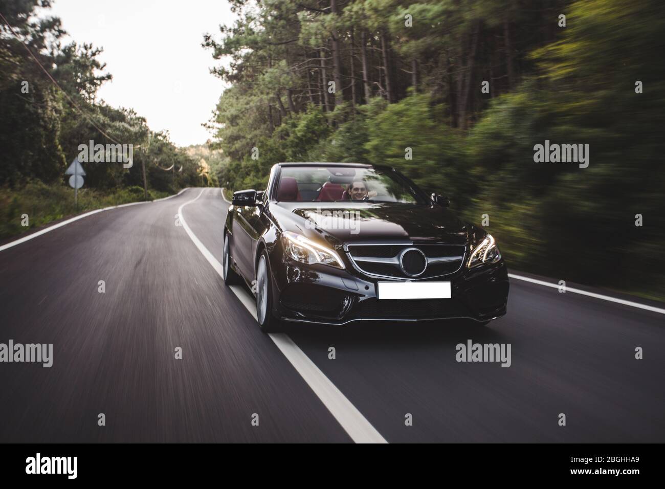 Black luxury design sedan travelling in the forest Stock Photo - Alamy