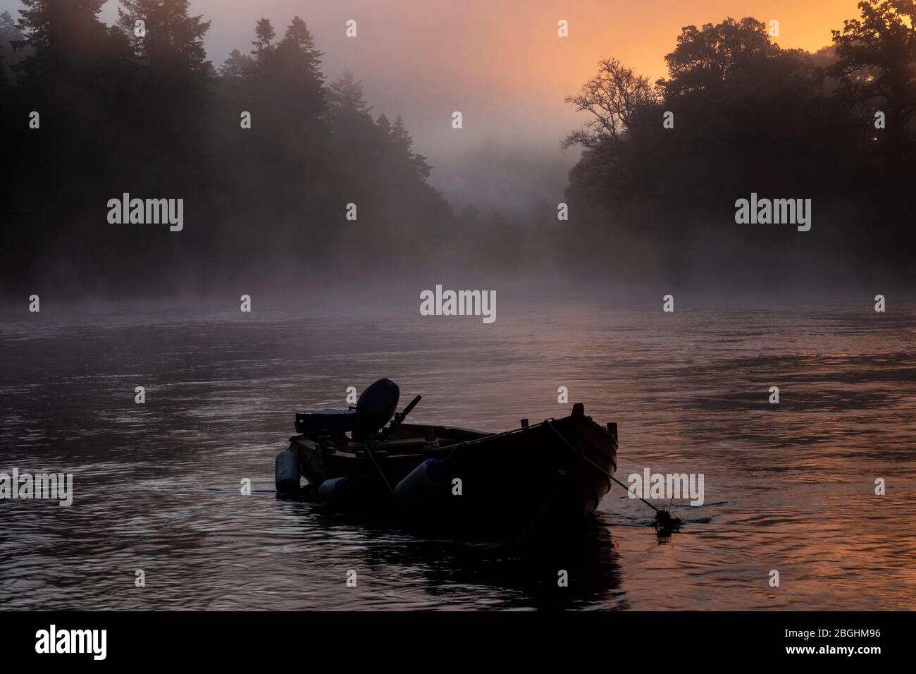Boat on a misty river Stock Photo