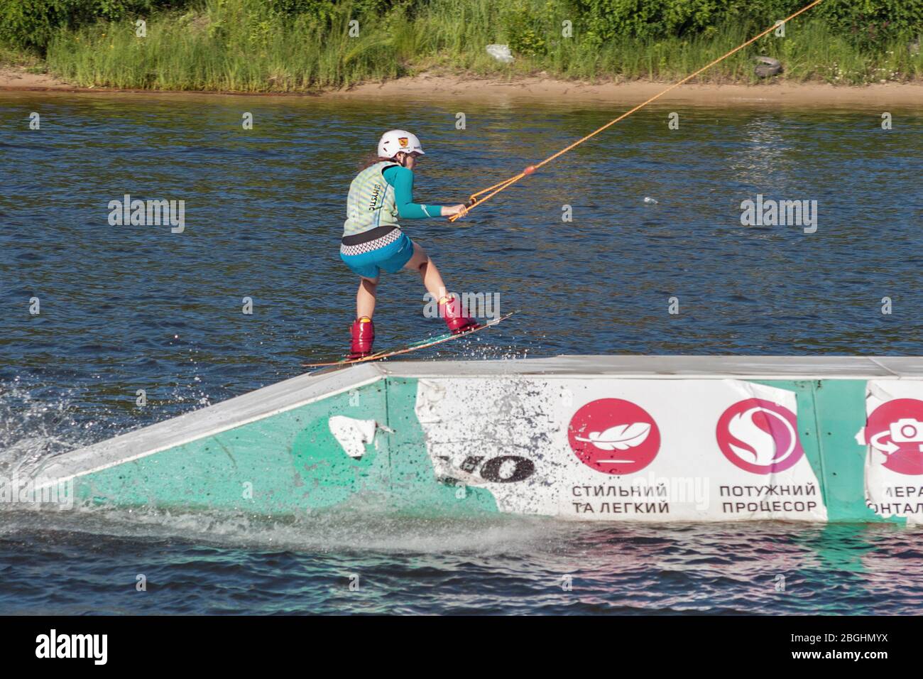 KYIV, UKRAINE - JUNE 05, 2015: Young woman wakesurfing at cables wake park in sports and entertainment complex X-Park, Friendship of Nations Park, Yur Stock Photo