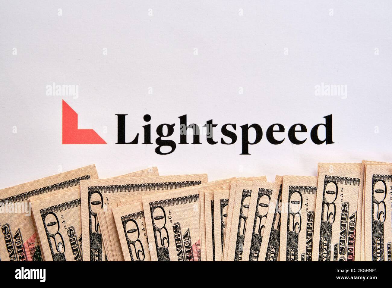 Stone / United Kingdom - April 15 2020: Lightspeed Venture Partners company logo printed on paper and US dollars placed on top. Concept. Stock Photo
