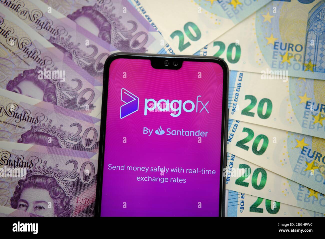 PagoFx money transfer app on the smartphone screen with pounds and EURO banknotes around it. Stock Photo