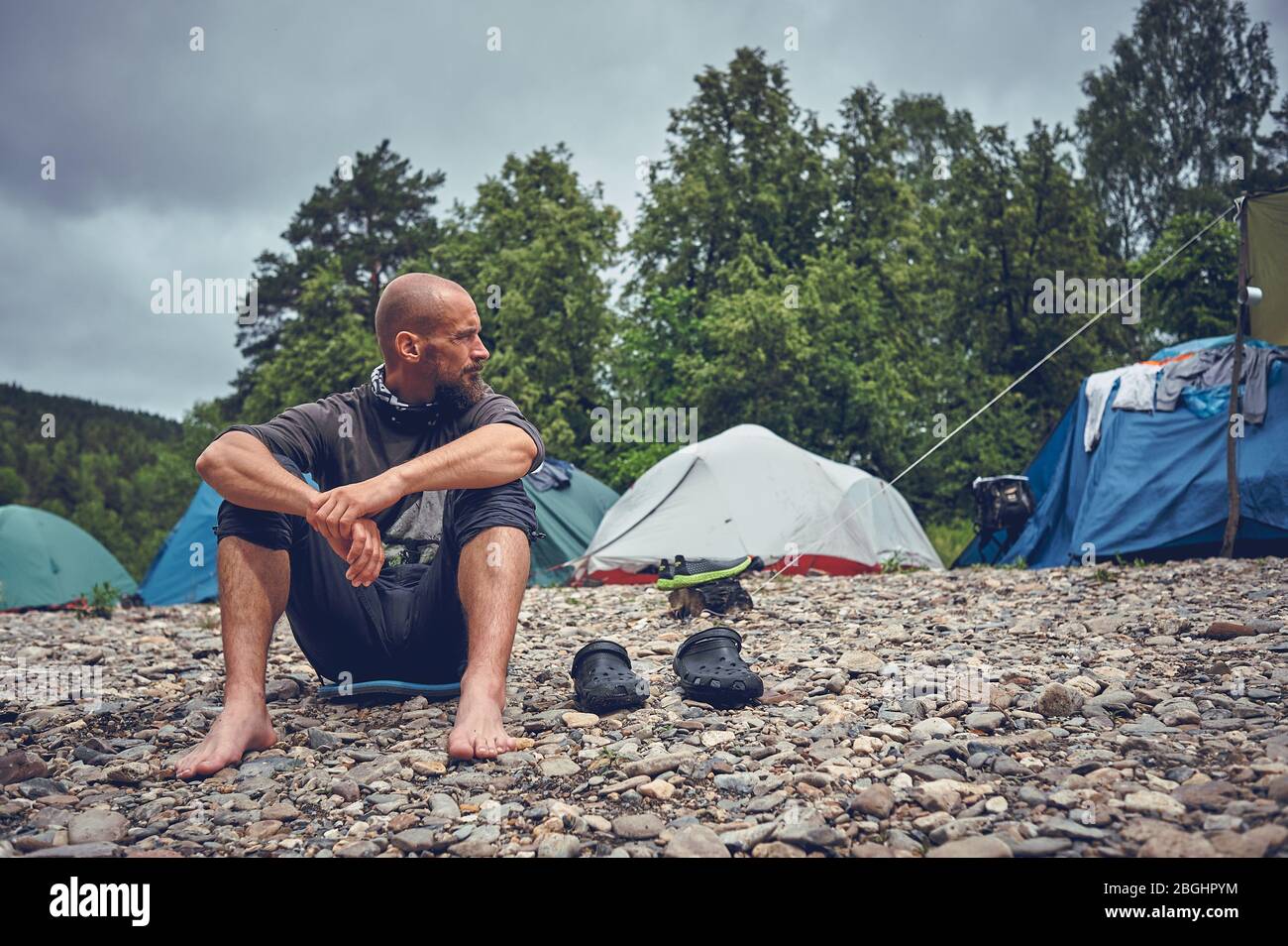 Tourist bearded man resting on the river. Stop and relax while traveling in nature. Stock Photo