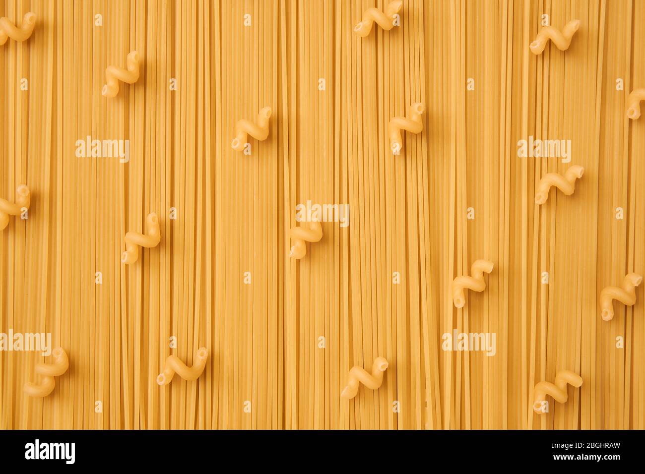 background of long and short-cut dry pasta, spaghetti and corkscrews Stock Photo