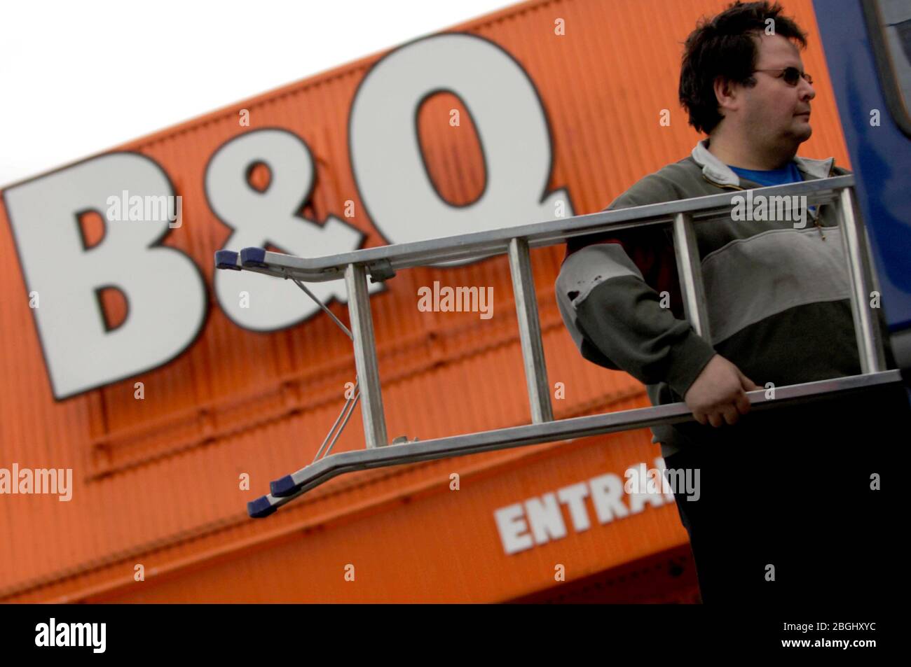 A B&Q customer loading a new ladder into his van Stock Photo Alamy