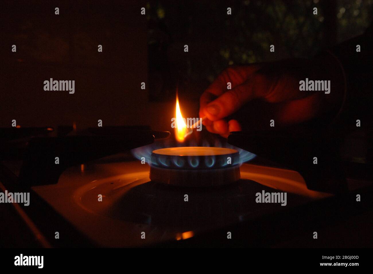 a man lighting a gas cooker ring by match Stock Photo Alamy