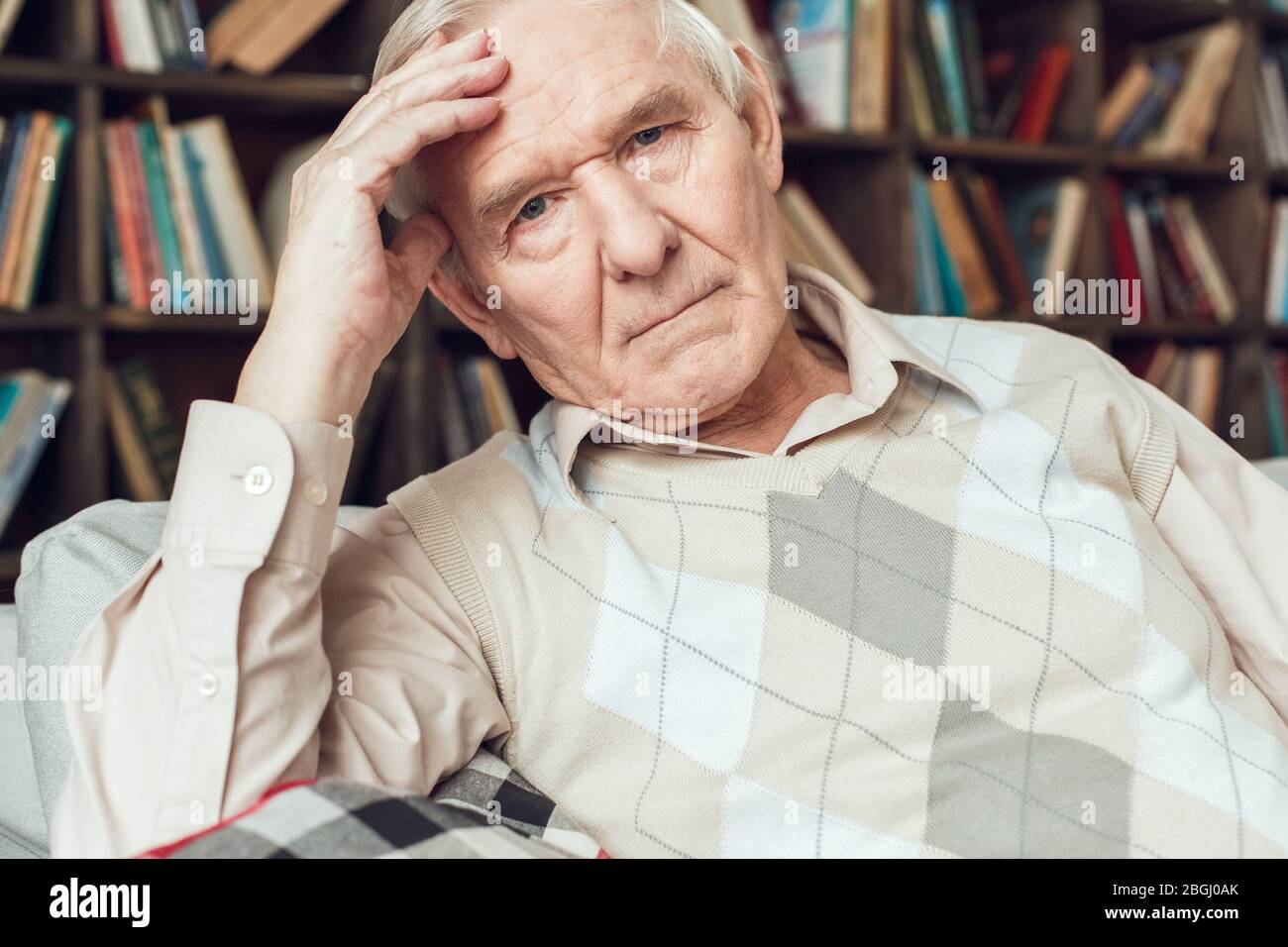 Senior man alone sitting at library tired Stock Photo