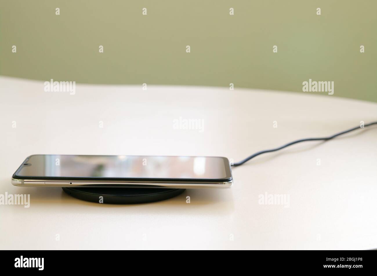 Smartphone wireless charging on induction charger. Wireless charger. Copy space Stock Photo