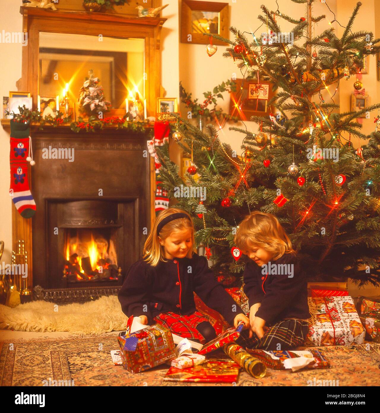 Children unwrapping presents at Christmas, Winkfield, Berkshire, United Kingdom Stock Photo