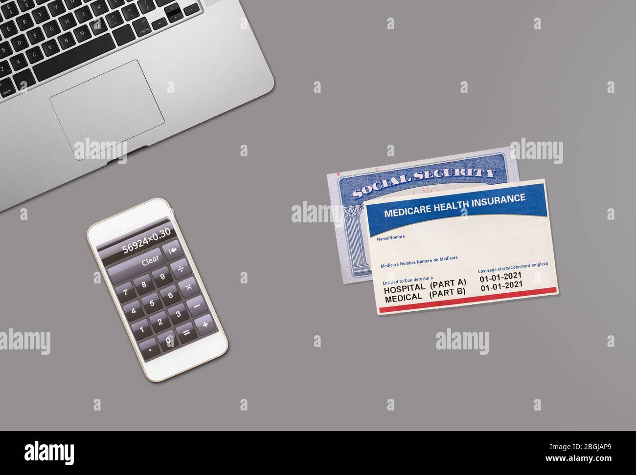Overhead clean desk for laptop, smartphone with social security and medicare cards to illustrate funding difficulties Stock Photo