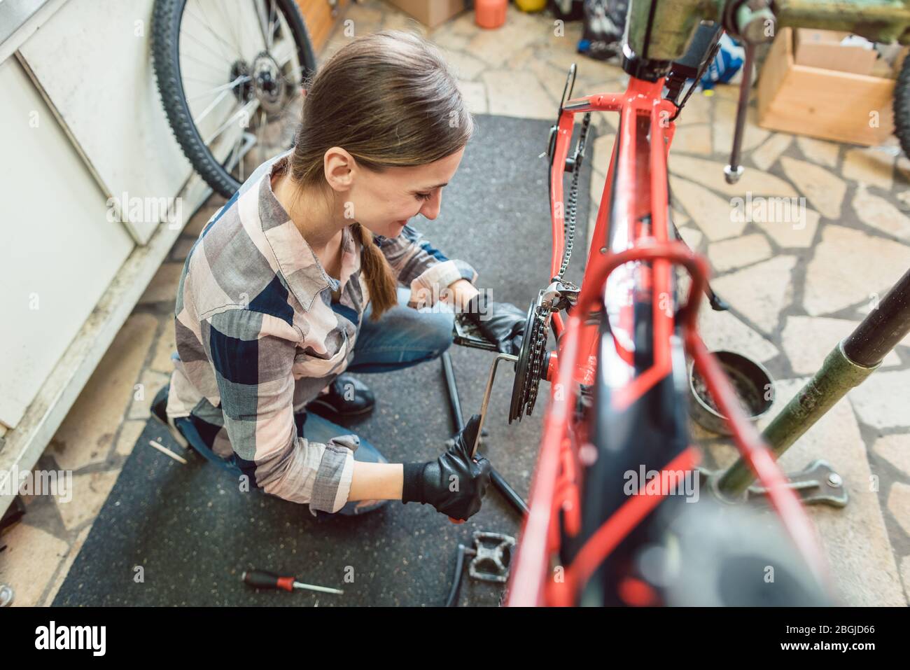 Bike technician in her workshop working on bicycle Stock Photo
