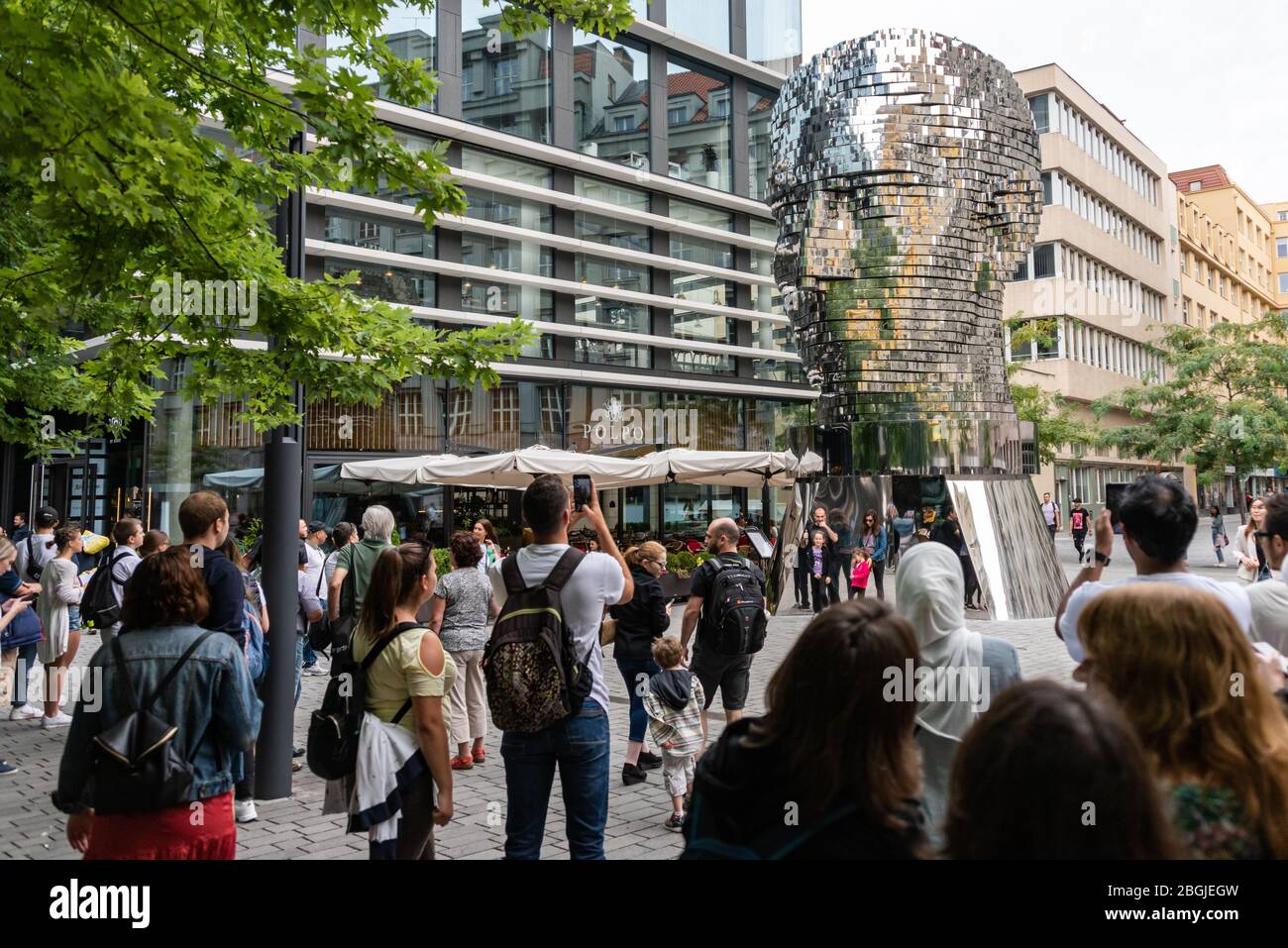 People, tourist watching The Head of Franz Kafka known as the Statue of Kafka outdoor sculpture by David Cerny, installed outside the Quadrio shopping Stock Photo