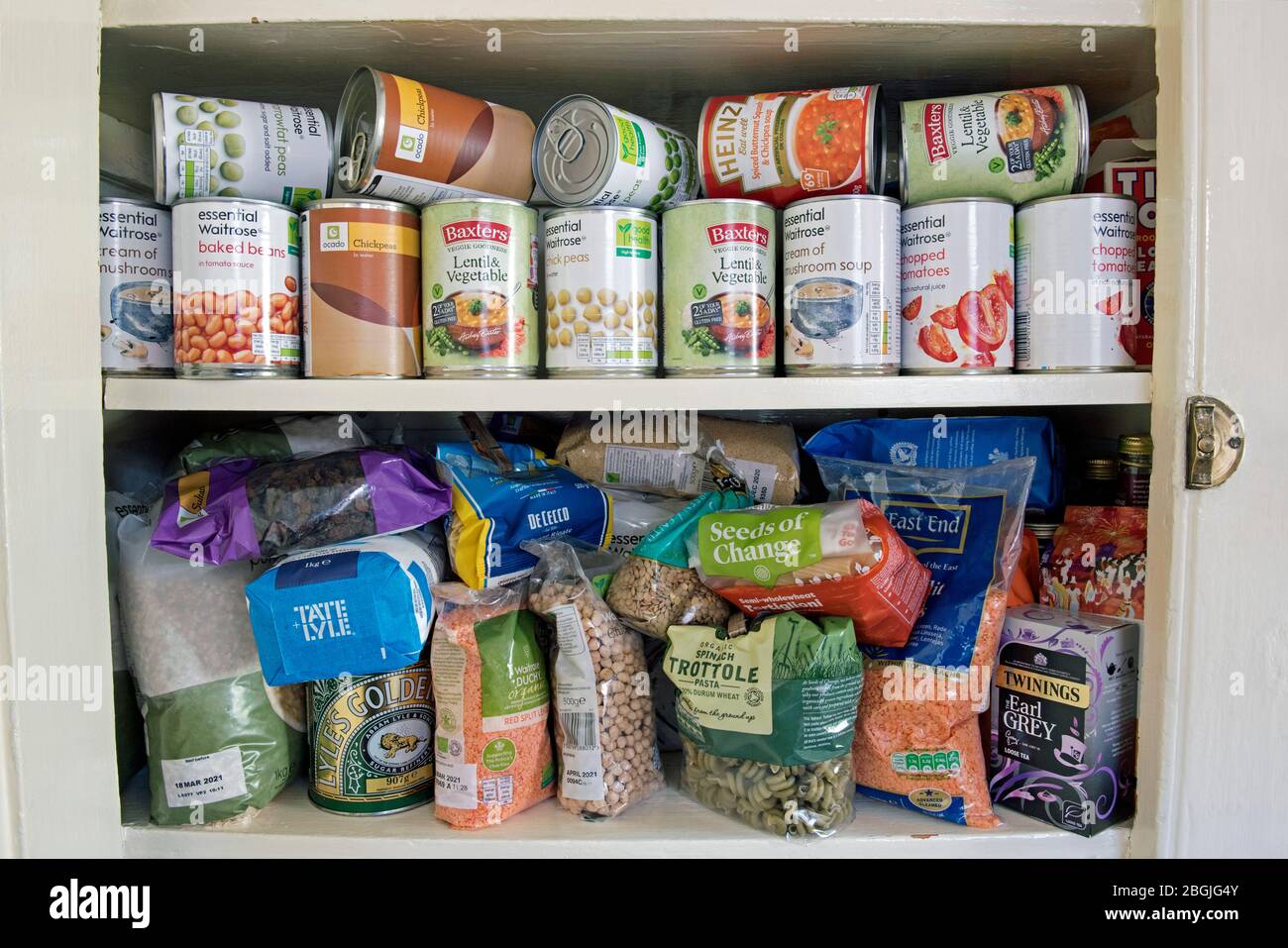 Tinned and packets of dried food, stockpiled tins of produce stored in cupboard, stockpiling due to the coronavirus corvid 19 pandemic lockdown London UK Stock Photo