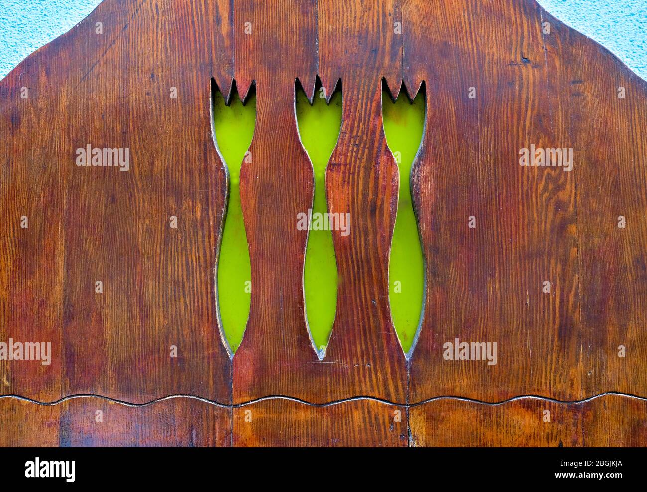 Three forks cutout in a wooden surface. Stock Photo