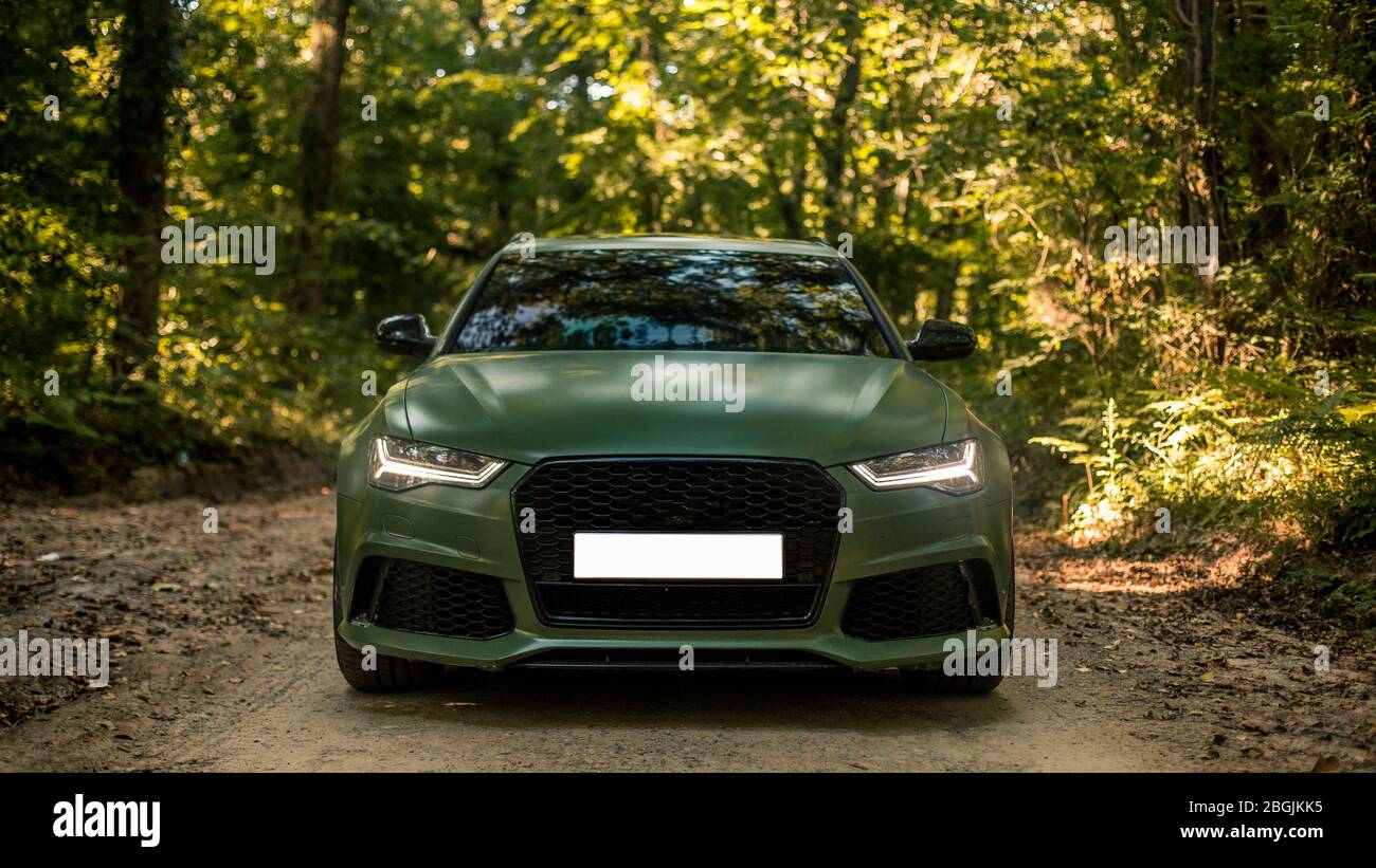 Parking a black sedan in the forest in the shadow Stock Photo - Alamy