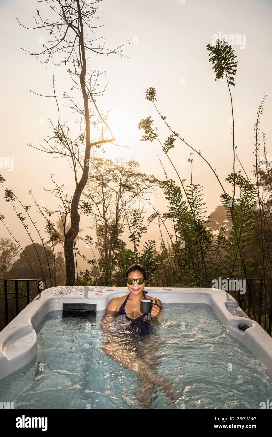 woman enjoying a bath in a hot tub in the Sri Lankan highlands Stock Photo