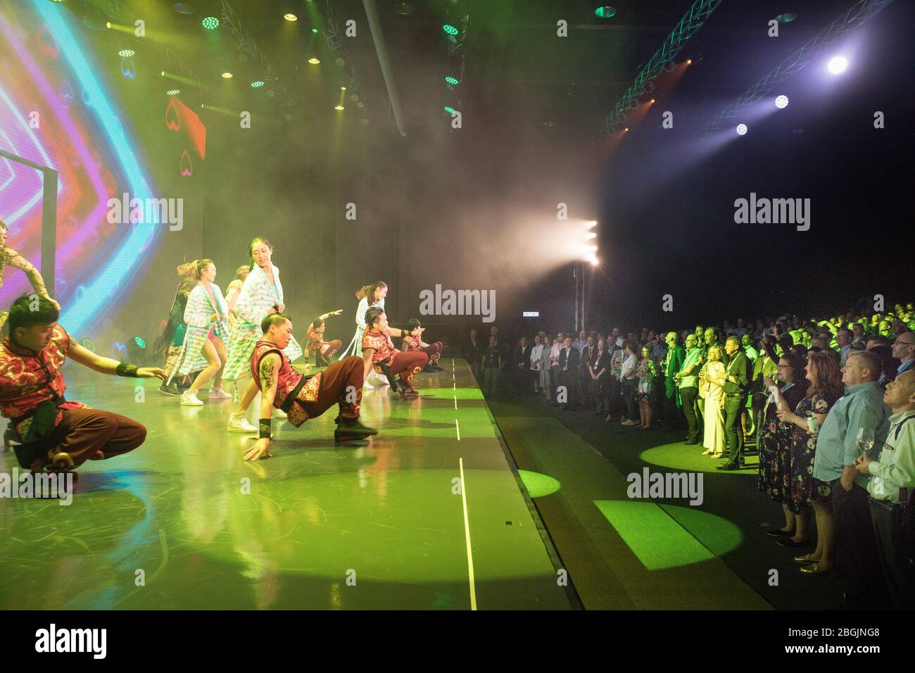 Chinese dancers perform for onstage as a large crowd looks on Stock Photo