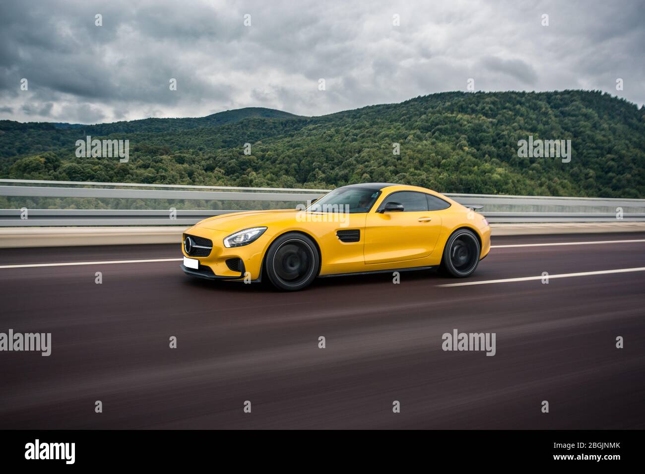 Yellow sport racing car autoshow in a stormy weather in the highlands ...