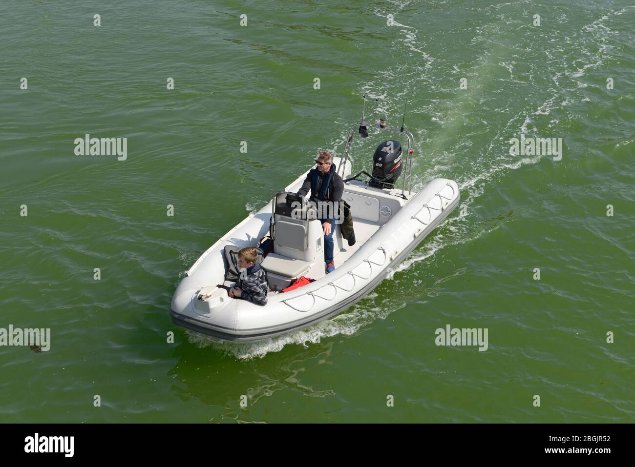 A Zodiac boat approaches a bridge over the river Arun in Littlehamption, West Sussex, UK Stock Photo