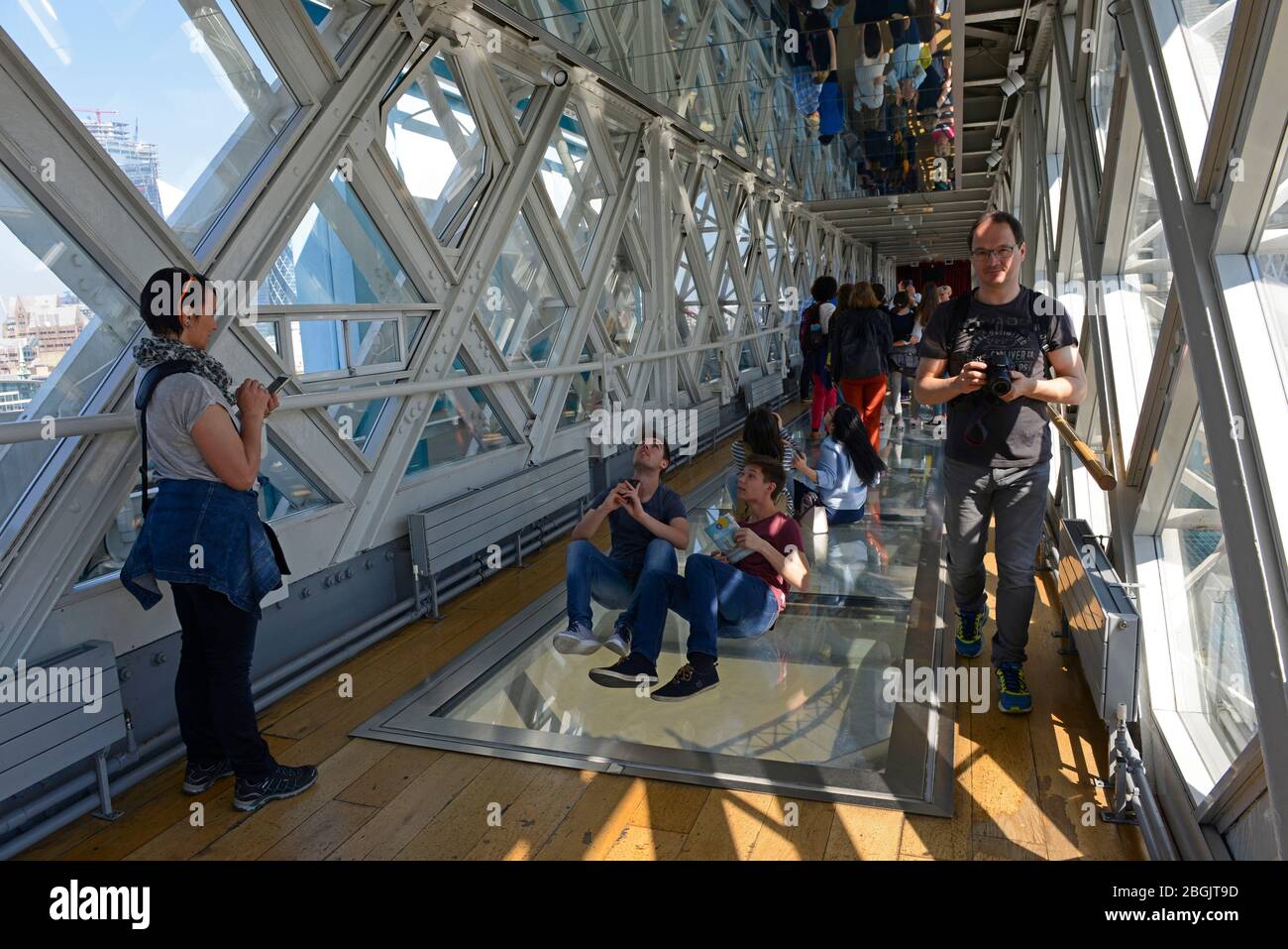 Visitors on one of the top arms of Tower Bridge take photos with the glass  floor below. London UK Stock Photo - Alamy