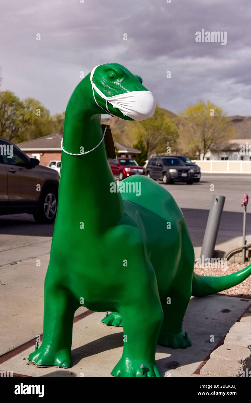 A Sinclair gas station dinosaur wearing a Covid-19 mask Stock Photo