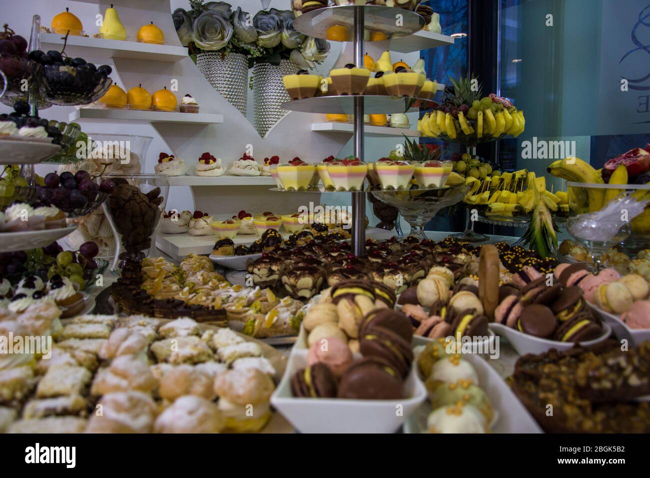 Candy bar at the wedding with different sorts of fruits and cookies in
