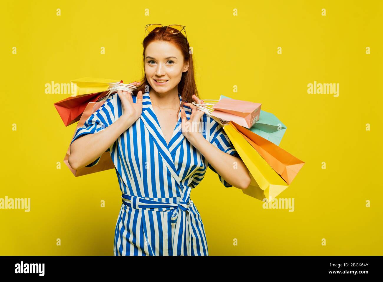 Stylish trending template for advertising. Funny girl drags a large number  of shopping bags. The concept of a strong and independent woman Stock Photo  - Alamy