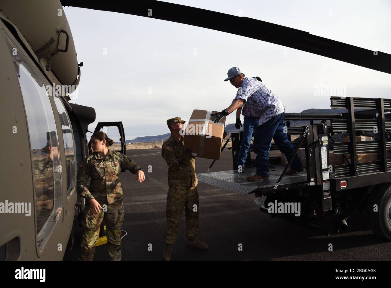 2nd Lt. Maram Sweis, Arizona Army National Guard medical operations officer and Sgt. Jonathan Atcitty, Arizona Army National Guard crew chief, and Kayenta Hospital personnel, load medical personal protection equipment from a UH-60 Blackhawk into a truck March 31, 2020, in Kayenta, Ariz. The Arizona National Guard flew medical PPE to the local hospital in response to COVID-19. The Arizona Guard has responded domestically in such emergencies as airport security after 9/11, Monument Fire in 2011, Hurricane Harvey in 2017, and the Havasupai Floods in 2018 (U.S. Air National Guard photo by Tech. Sg Stock Photo