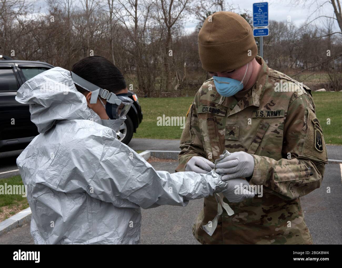 Soldiers and Airmen from the Massachusetts National Guard go through a detailed decontamination process and remove their personal protective equipment (PPE) after completing COVID-19 testing on residents at Alliance at West Acres nursing home, Brockton, Mass., April 10, 2020. The decontamination process includes safely removing the PPE and being sprayed with chemicals to remove any possible contaminants that they may have come in contact with. Twelve medical teams are activated throughout the state and are conducting COVID-19 testing at medical facilities and nursing homes with high-risk popul Stock Photo