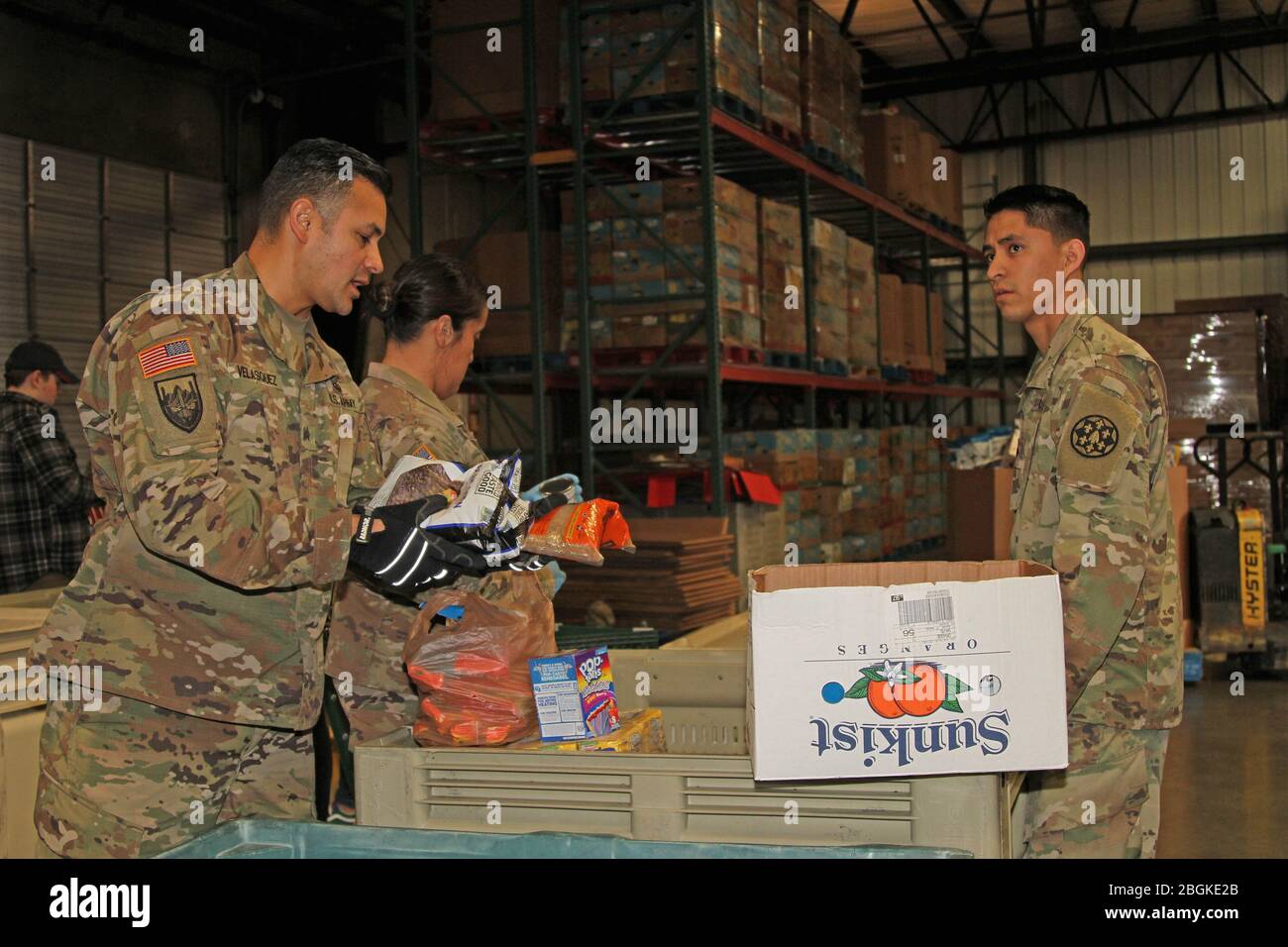 U.S. Army Sgt. Dimas Velasquez, left, of the 233rd Engineer Detachment (Fire Truck), 115th Regional Support Group, California Army National Guard, and other Cal Guardsmen sort out food March 20 at the Sacramento Food Bank & Family Service in Sacramento, California. The Guardsmen were activated to assist the state during the recent COVID-19 outbreak. (Army National Guard photo by Staff Sgt. Eddie Siguenza) Stock Photo
