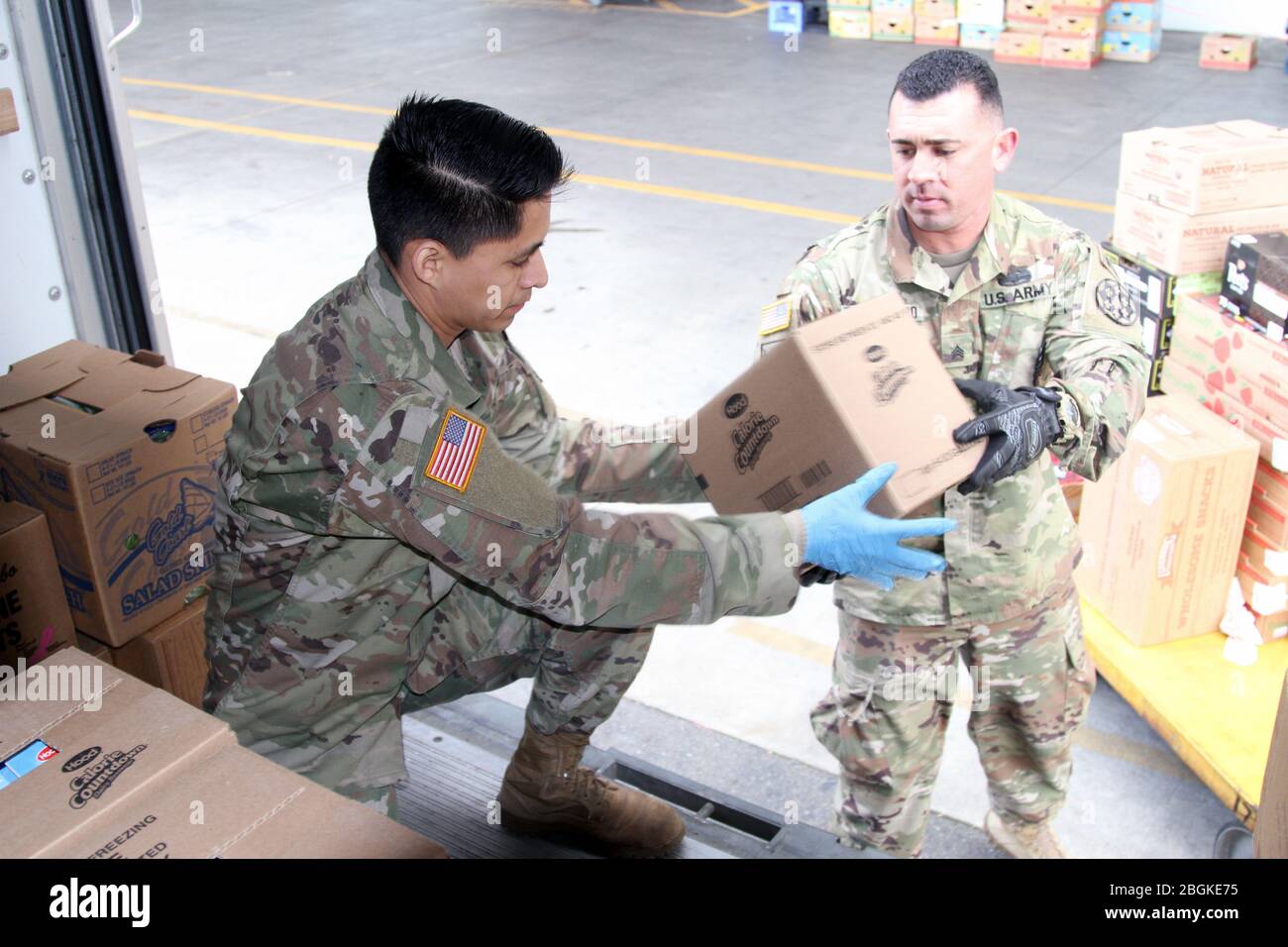 California Army National Guardsmen under the 115th Regional Support Group load a truck with food supplies March 31 at the Sacramento Food Bank & Family Services’ distribution outlet in Sacramento, California. After weeks of COVID-19 humanitarian support, the Guardsmen are adding to their responsibilities by now serving as truck drivers, delivering food from the facility out to the public. (Army National Guard photo by Staff Sgt. Eddie Siguenza) Stock Photo