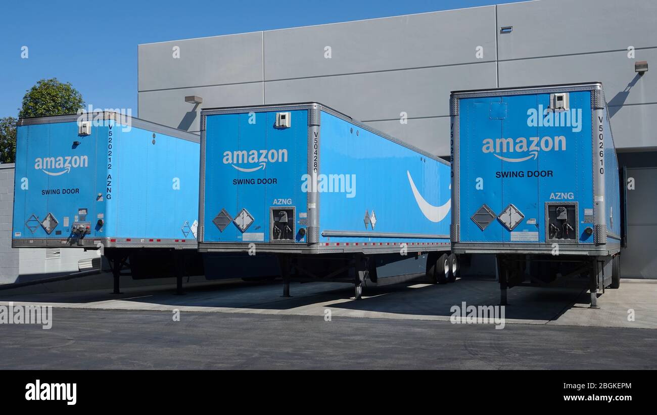 Amazon trucks parked at loading dock at regional fulfillment center. Stock Photo