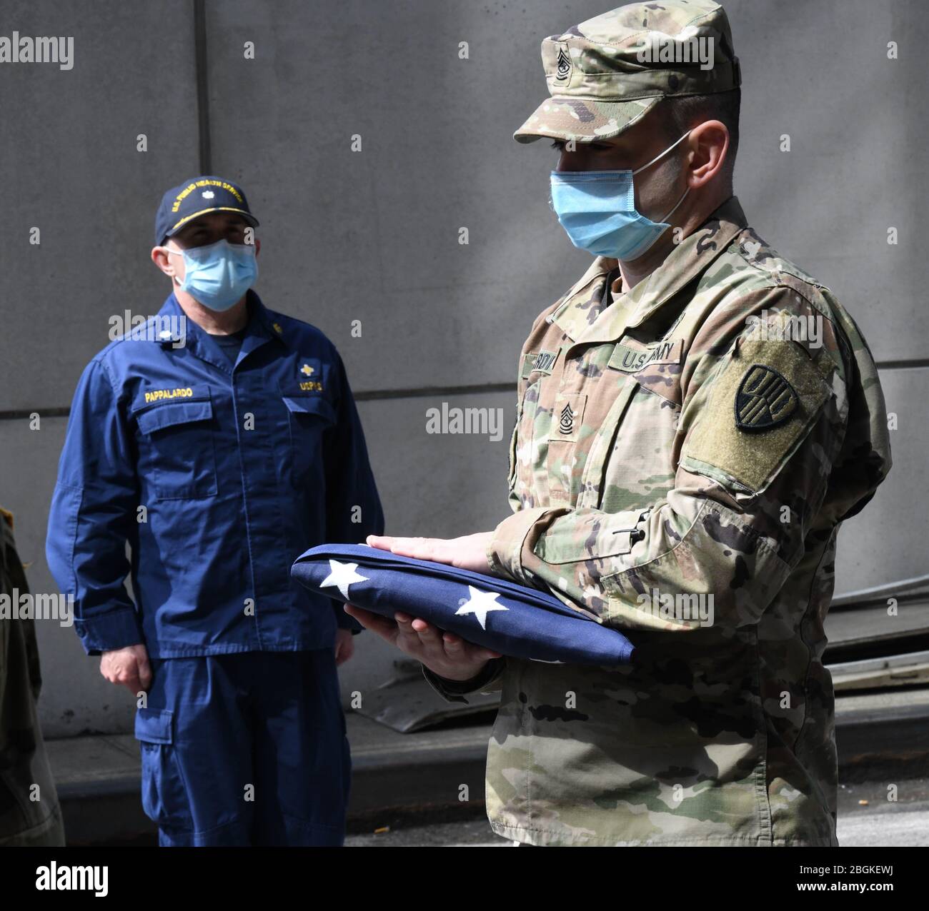 New York Army National Guard Sgt. Major Nicholas Pardi, a member of the 104th Military Police Battalion, presents an American flag during a memorial service for a  veteran who died of COVID 19 while a patient at the Javits New York Medical Station erected at the  Jacob Javits Convention Center in New York City, on on April 19, 2020. Active military and members of the New York National Guard Military, along with staffers who are prior service military, rendered final honors as his remains were transferred ( U.S. Air National Guard photo by Major Patrick Cordova) Stock Photo