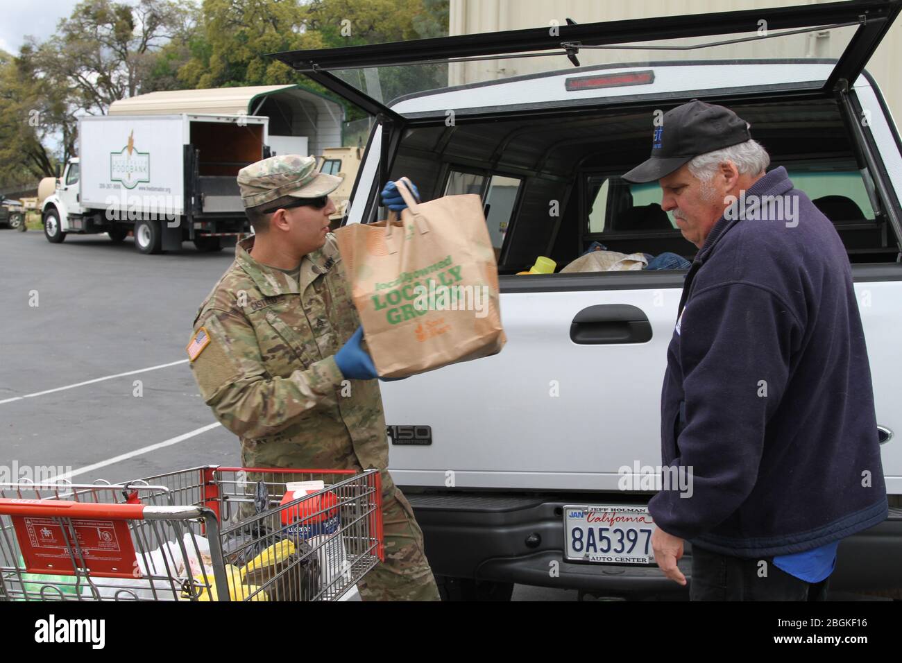 U.S. Army Sgt. Moises Castillo of the California Army National Guard’s 1040th Quartermaster Company, 340th Brigade Support Battalion, 115th Regional Support Group, helps an Amador County resident load food supplies into a vehicle March 23 at the Interfaith Food Bank in Jackson, California. The Cal Guard ramped up its humanitarian support following the recent activation by Gov. Gavin Newsom’s call-up of the reserve component. (Army National Guard photo by Staff Sgt. Eddie Siguenza) Stock Photo