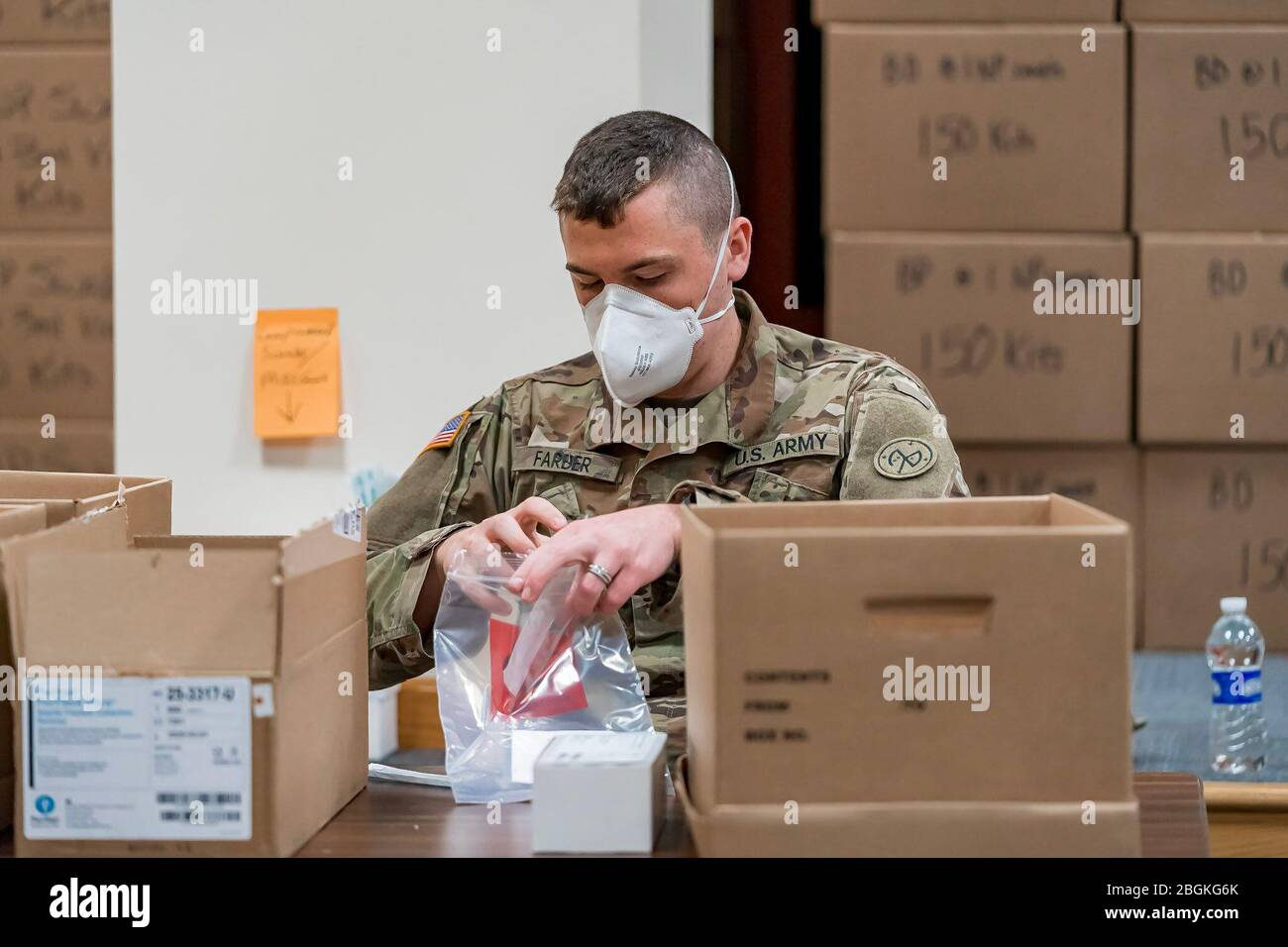 New York Army National Guard Spc. Justin Farber, assembles novel coronavirus (COVID-19) specimen collection test kits at the New York State Department of Health’s Wadsworth Center in Albany, N.Y., April 4, 2020. These test kits will be utilized at drive through sample sites across the state as part of the statewide effort of more than 2,700 members of the New York National Guard responding to community needs to mitigate the effects of the COVID 19 pandemic. N.Y. State Department of Health photo by Mike Wren. Stock Photo