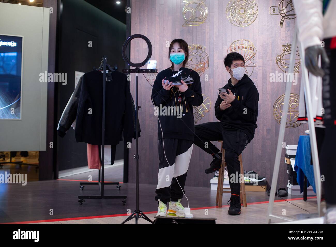 Shopping guides at INtime shopping mall, who faces few customers, turn to be online streamers, attempting to sell products via Internet, Hangzhou city Stock Photo