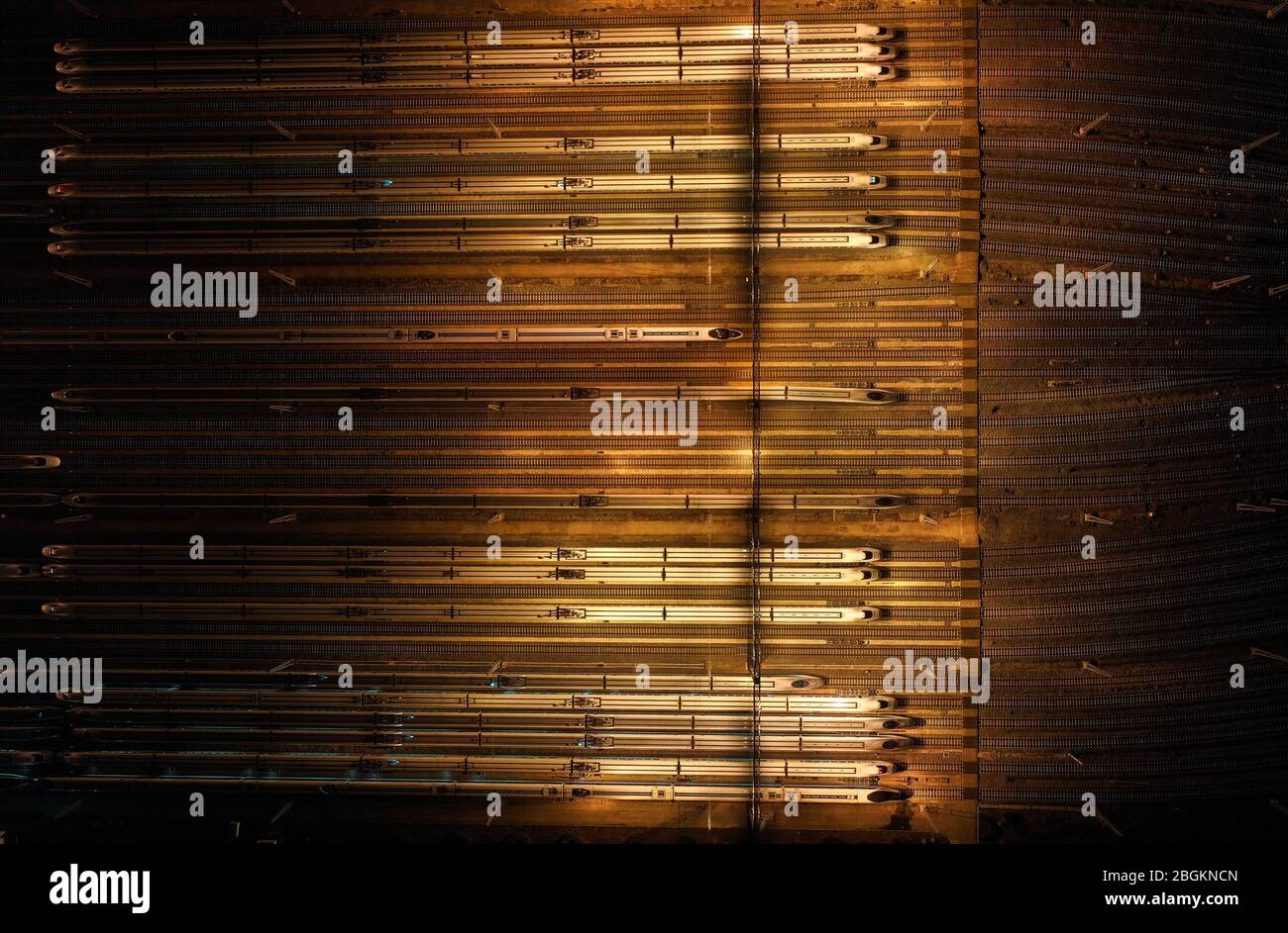 An aerial view of high-speed trains gathering at night after ...