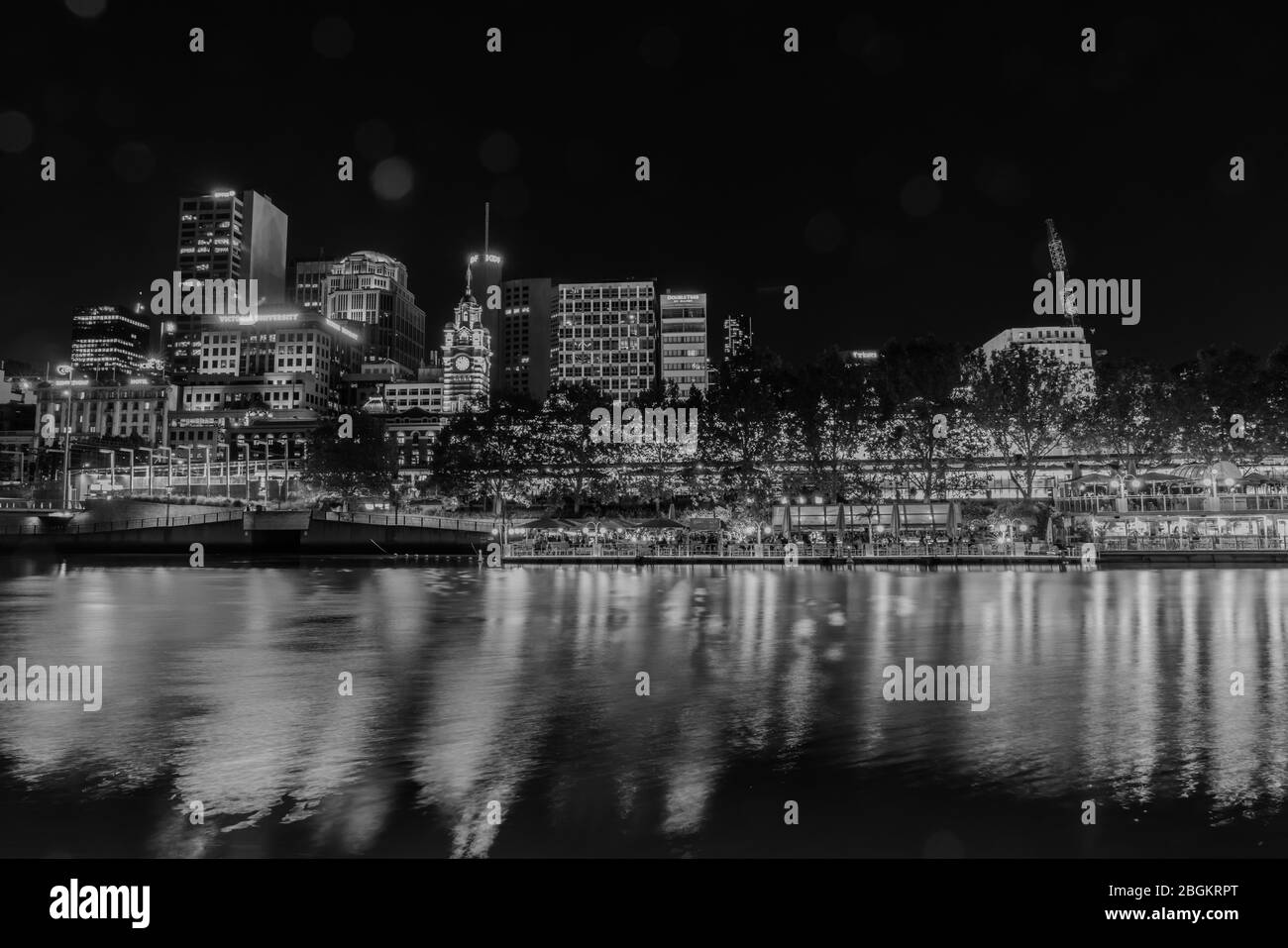 Melbourne Australia - March 9 2020; City at night, buildings, lights and corporate brands neon signs across Yarra River in monochrome. Stock Photo