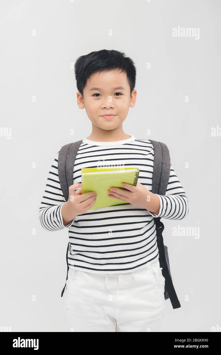 cute elementary school boy holding books on white background Stock ...
