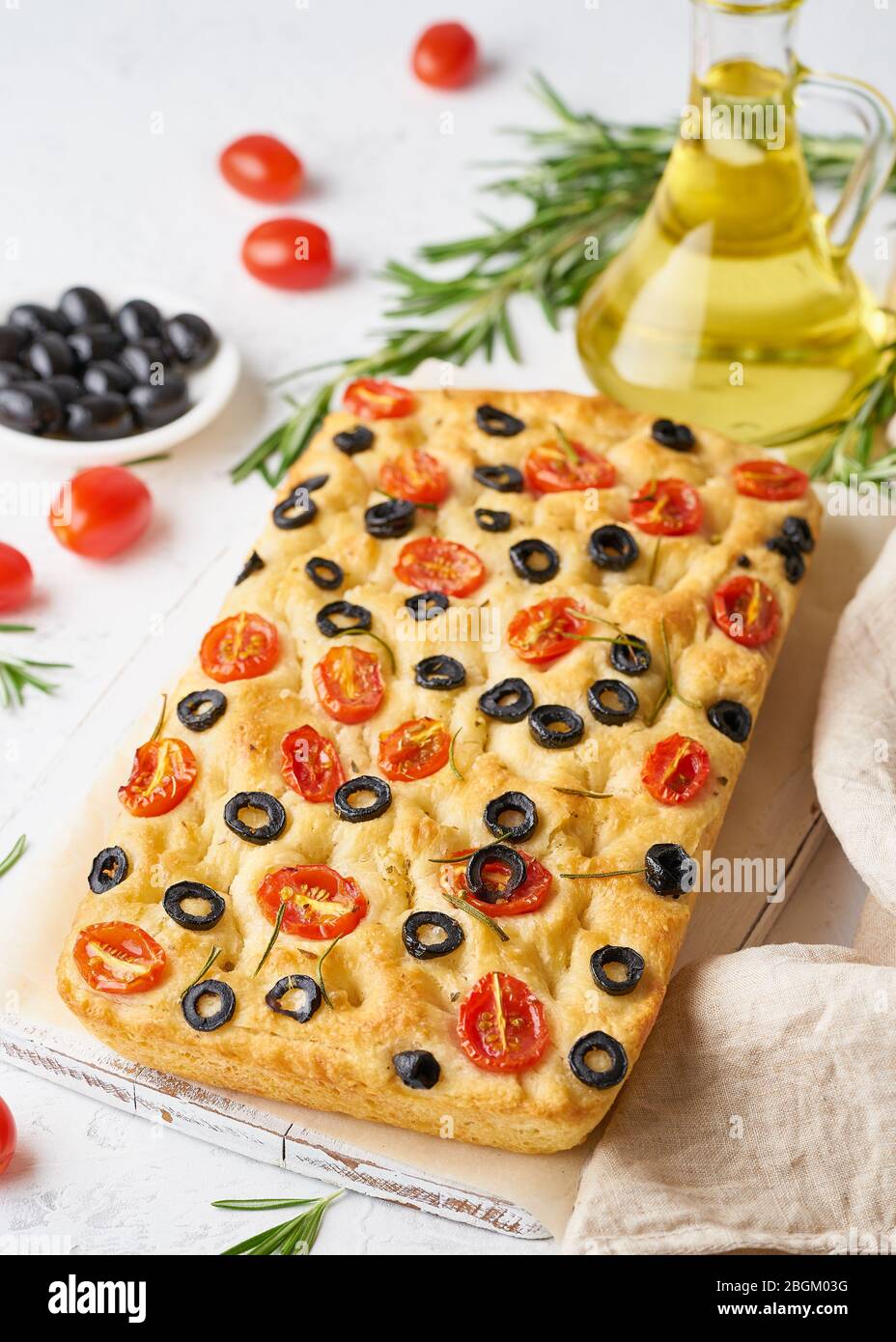Focaccia with tomatoes, olives and rosemary, vertical. Whole Italian