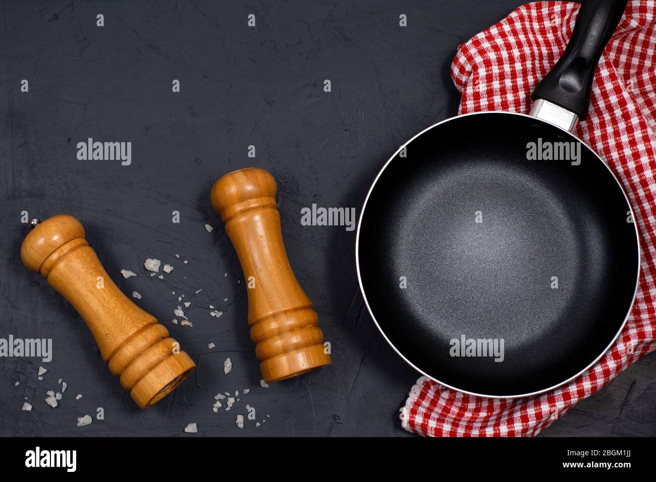 Empty black frying pan or skillet with pepper and sea salt Stock Photo