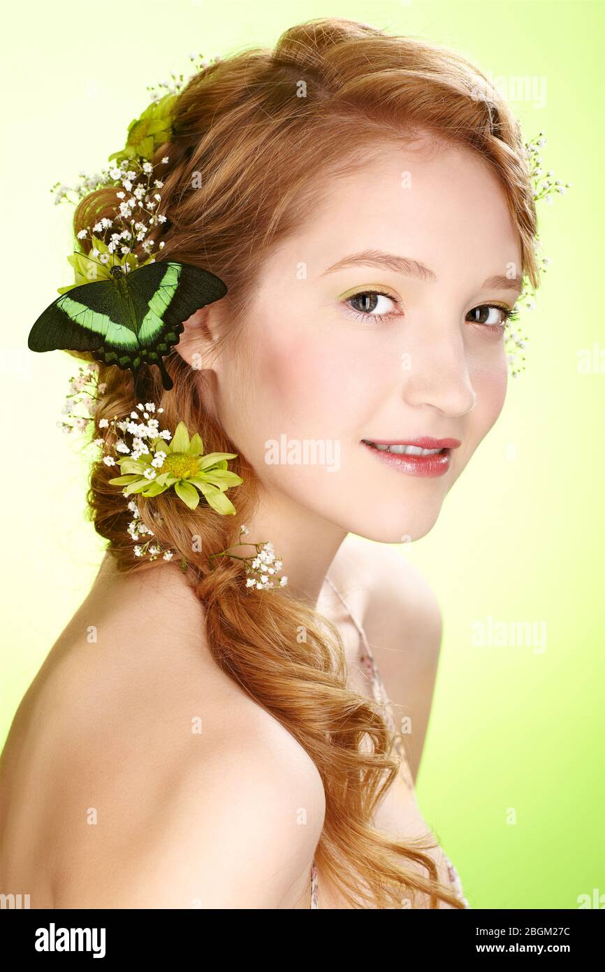 portrait of beautiful healthy redhead teen girl with flowers and butterfly on her hair Stock Photo