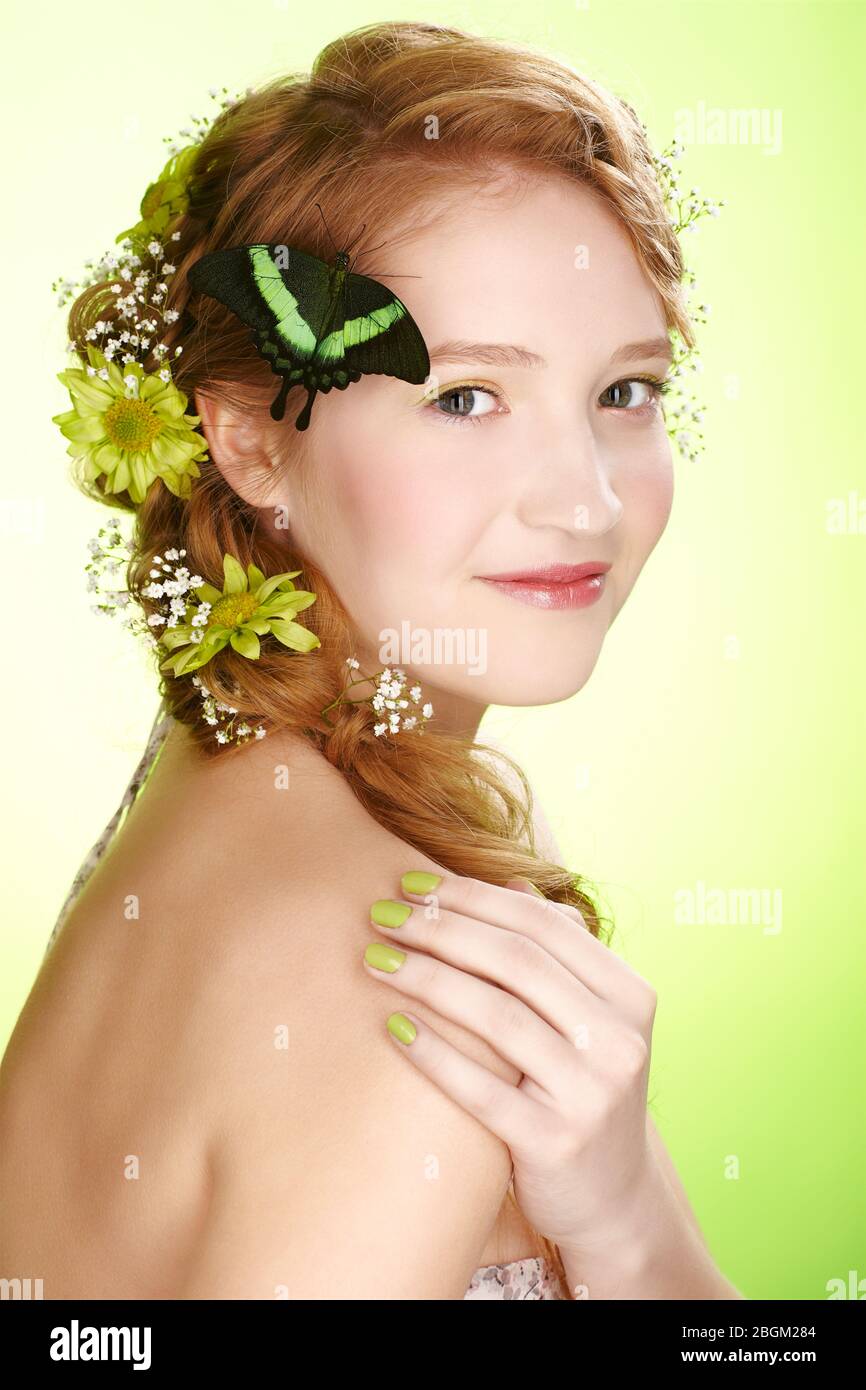 portrait of beautiful healthy redhead teen girl with flowers and butterfly on her hair Stock Photo