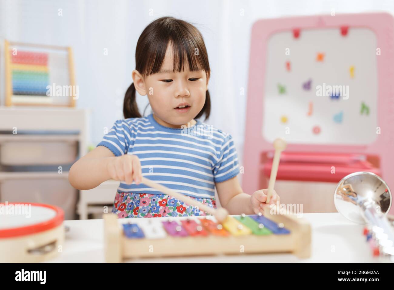 toddler girl play xylophone at home for homeschooling Stock Photo Alamy